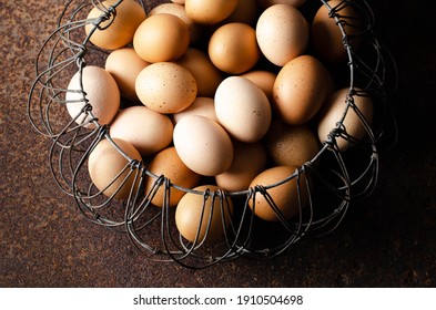 Eggs in a wired basket on a dark backdrop.  - Powered by Shutterstock