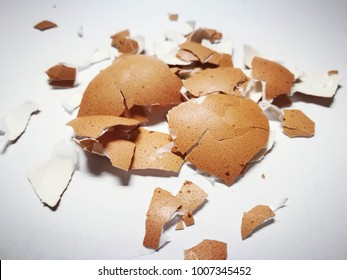 eggshell cracks on a white background and broken eggshells on a table, The shells are mostly white, but there are also a few brown ones.  - Powered by Shutterstock - Get 15% off with code: PIKWIZARD15