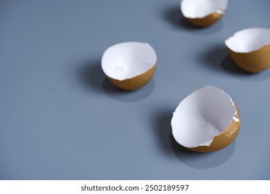 Eggshell on grey background. Close-up dry and clean eggshells texture with shadow. Dry objects from food, texture, broken, organic, and cooking concerts. Cracked eggshell shows white skin inside. - Powered by Shutterstock - Get 15% off with code: PIKWIZARD15
