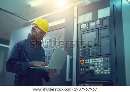 The egineer in the industial working with computer control the machine