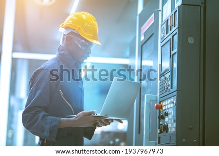 The egineer in the industial working with computer control the machine