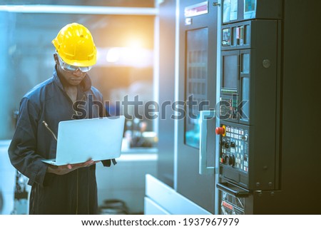 The egineer in the industial working with computer control the machine