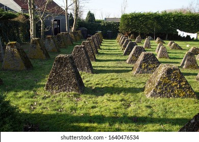 Egmond Aan Den Hoef. Netherlands, February 7, 2020. Concrete Dragons Teeth, Remains Of World War 2 Used To Stop Allied Tanks. Part Of The Atlantic Wall Together With The Bunkers. On A Lawn Of A House.