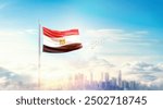 Egypt flag wavering in beautiful clouds with building skyline. The flag with drone shot in beautiful sky. Egypt national flag for independence day.