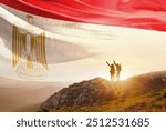 Egypt flag waving in the sky. A couple hike and enjoy a break look at the top of the mountain adventure travel. Egypt national flag for independence day.