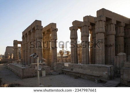 Egypt, Luxor temple colonnade of Great Sun court of Amenhotep III early morning with Minaret of Ahmed Negm Mosque in middle, Ancient Egyptian architecture