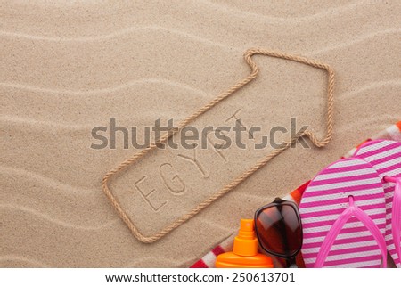 Egypt pointer and beach accessories lying on the sand, as background