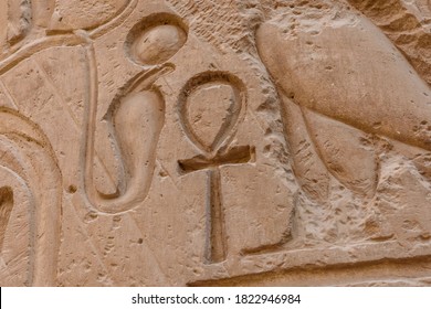 Egyptian ancient hieroglyphs on a stone wall. Closeup of symbol of eternal life ankh