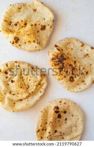 Egyptian Arab flatbreads - Aish Baladi top view on beige background. Vertical format