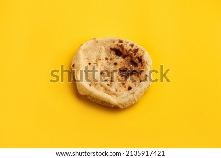 Egyptian bread Aish Baladi. Fresh bread lies on the yellow table
