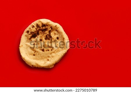 Egyptian bread Aish Baladi. Fresh bread lies on the red table