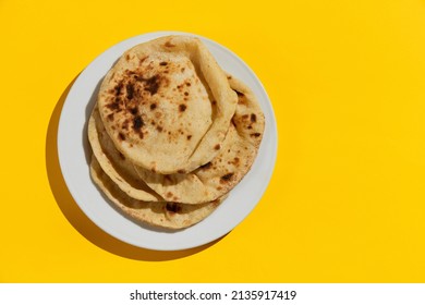 Egyptian bread Aish Baladi on. A lot of fresh bread lies on the yellow table - Shutterstock ID 2135917419