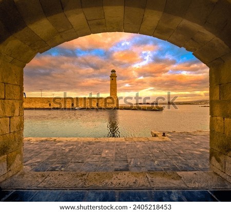 The Egyptian lighthouse at the old harbor of Rethimno through a frame of an arched door, Crete, Greece.