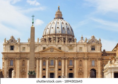Egyptian obelisk, made of red granite with bronze lions and Chigi arms and St. Peter's Basilica with Michelangelo's dome on the St. Peter's Square in Vatican City. Famous Italian landmark