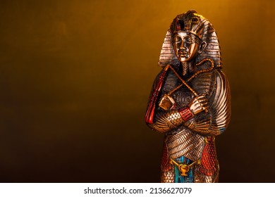 Egyptian pharaoh figurine in orange smoke on a black background. - Shutterstock ID 2136627079