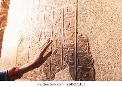 An Egyptologist or archaeologist reads and translates Egyptian hieroglyphs carved in stone - Shutterstock ID 2145275137