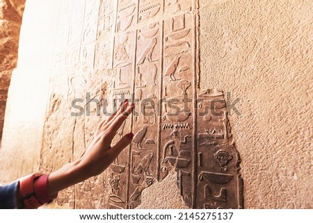 An Egyptologist or archaeologist reads and translates Egyptian hieroglyphs carved in stone