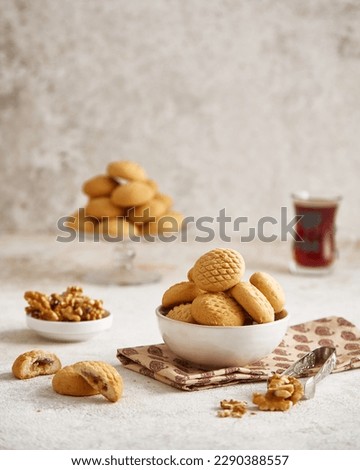 Eid Islamic Feast Cookies (maamoul or mamoul cookies) Sprinkling powdered sugar on Kahk, Traditional arabic Eid al Adha, Eid al Fitr sweets
