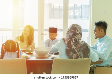 Eid Mubarak Celebration Moment, Malay Family Having A Meal At The Dining Table Having Lunch