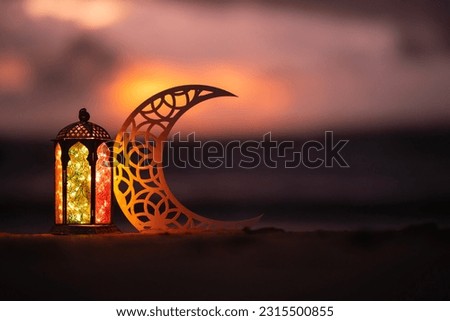 Eid Mubarak concept background with copy space, Crescent moon shape with Ramadan lantern lamp in the beach with dramatic sky on the background, Islamic New Year image