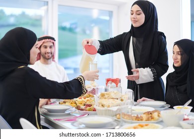 Eid Mubarak Muslim Family Having Iftar Dinner Drinking Water To Break Feast. Eating Traditional Food During Ramadan Feasting Month At Home. The Islamic Halal Eating And Drinking 