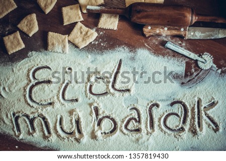Eid Mubarak phrase written on flour. The preparation process of traditional Arabic or Muslim cooks