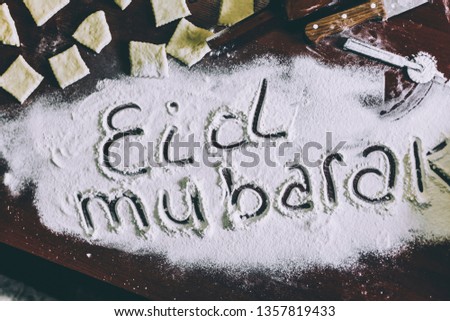 Eid Mubarak phrase written on flour. Preparation process of traditional arabic muslim cooks