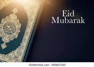 EID MUBARAK text and Holy Quran with arabic calligraphies translation meaning of Al-Quran on black background. Ramadan,Hajj, Islamic and Copy Space concept