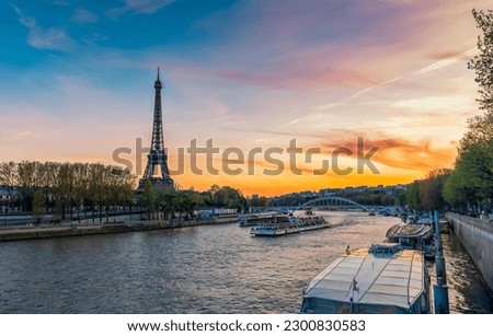 Eiffel Tower against colorful sunset sky by Seine River in Paris. Late afternoon light