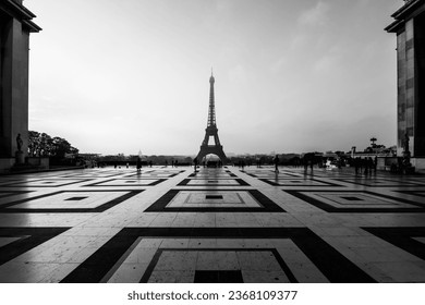 Eiffel Tower, French: Tour Eiffel, silhouette at dawn. View from Trocadero Square with geometrical marble pavement. Paris, France. Black and white photography.