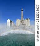 The Eiffel Tower in Las Vegas behind the bellagio fountains, a rainbow in the mist.