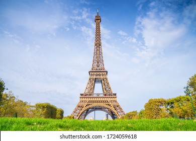 Eiffel Tower on blue sky background in summer sunny day. View on Eiffel tower from Mars fields without tourists. Sunny Paris cityscape.