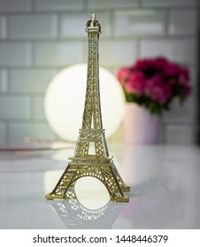 Eiffel tower on a table with a lantern and a flower