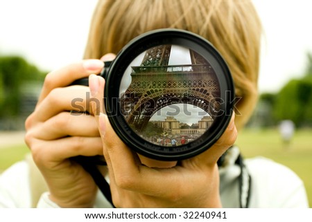 Eiffel tower reflection in camera lens with blurred woman face