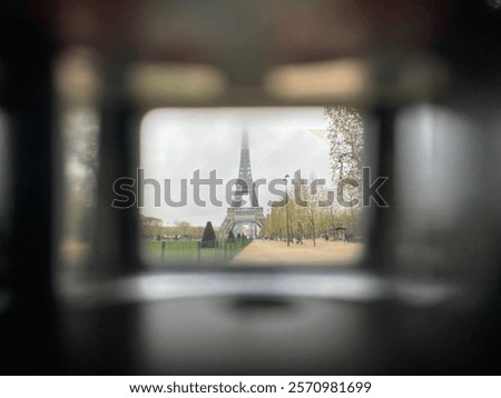 The Eiffel Tower seen through a camera viewfinder, surrounded by a clear sky.