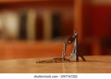 An Eiffel Tower Shaped Key Chain Placed On A Table.