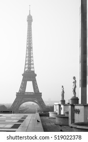 Eiffel Tower In The Summer Morning Fog With Golden Statue On The Terrace Near Palais De Chaillot In Black And White. Paris, France.