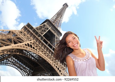 Eiffel Tower Tourist Posing Smiling By Eiffel Tower, Paris, France During Europe Travel Trip. Young Happy Excited Multiracial Asian Caucasian Woman In Her 20s.