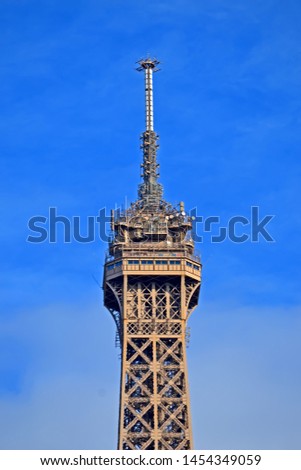 Eiffel tower with upper antenna and microwave radio transmitter heap on blue sky with clouds, Europe travel diversity