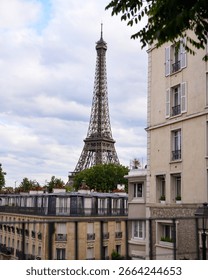Eiffel Tower view framed by Parisian buildings on a cloudy day