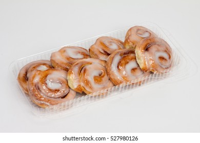 Eight Cinnamon Rolls In Small Plastic Container.