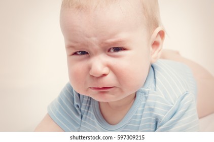 Eight month old baby crying. Sad child portrait