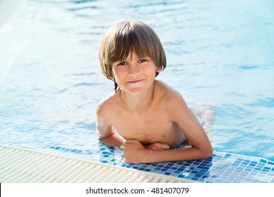 An Eight Years Old Boy In Swimming Pool In Sunny Hot Day