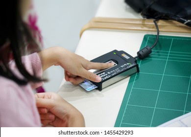 Ekamai Gateway community mall, Bangkok, Thailand (16 Jul 19)- Thai little girl is pressing index against scanner to record fingerprint in her first national ID card at BMA Express service center