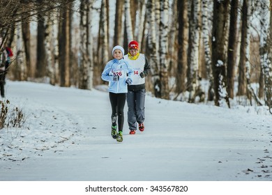 Ekaterinburg, Russia - November 14, 2015: Grandson And His Grandmother Running Through Winter Woods Together During Urban Winter Marathon