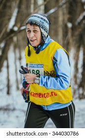 Ekaterinburg, Russia - November 14, 2015: Elderly Looking Woman Athlete Running On Snowy Road In Forest During Urban Winter Marathon