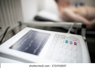 EKG Machine Showing The Blood Pressure Waves While A Patient With EKG Electrodes Attached To His Body.