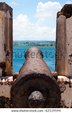 El Morro Fort Cannon covered in rust points out towards the ocean.