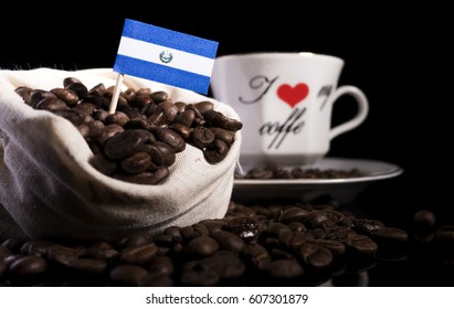 El Salvadoran Flag In A Bag With Coffee Beans Isolated On Black Background