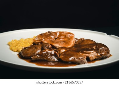 An Elaborate Meal Presentation Of A Thick-cut Round Steak. After The Meat Is Cooked, It Becomes Flat, Very Tasty And Served With Risotto. The Chef Pours Various Sauces On This Dish.